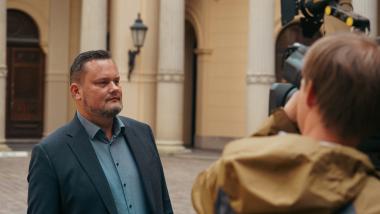 René Domke vor dem Schweriner Schloss vor einer Kamera